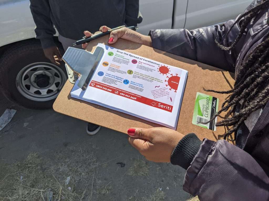 The food packs are handed out with COVID-19 awareness posters.